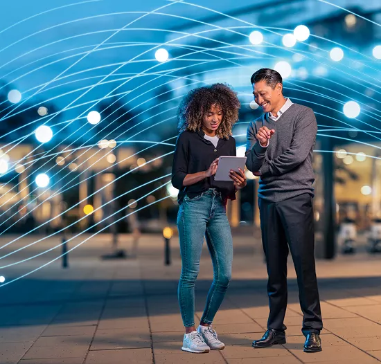 mindgrowing tttech group image. man and woman standing on the street and looking at a tablet